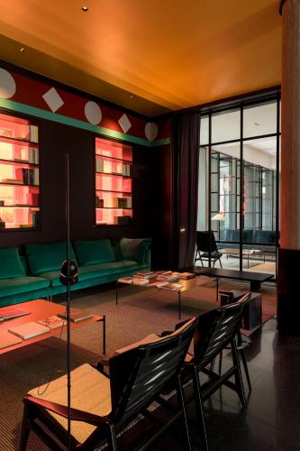 a living room with a green couch and tables at Habita79 Hotel Pompeii - MGallery Collection in Pompei