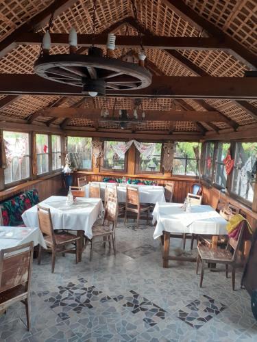 a dining room with white tables and chairs at Casa cu flori Murighiol in Murighiol