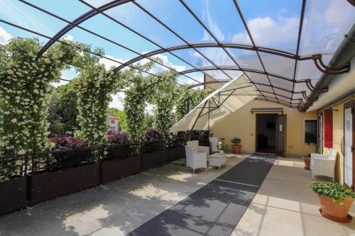 un techo de cristal sobre un patio con sillas y plantas en LOCANDA RIGHETTO en Quinto di Treviso