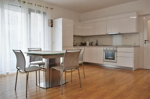a kitchen and dining room with a table and chairs at Top center apartment Gramophone with private parking in Burgas City