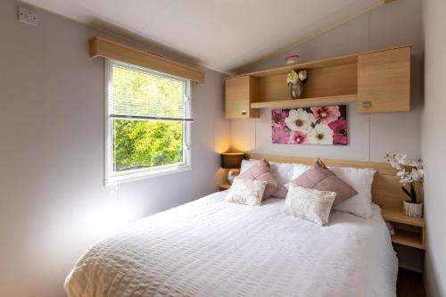 a bedroom with a white bed with pillows and a window at Inside No 9 Retreat Carnforth in Carnforth