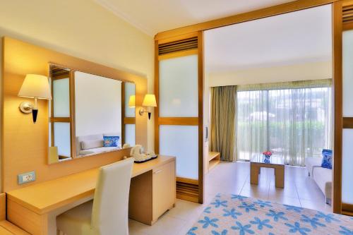 a bedroom with a desk and a large mirror at Sol Cosmopolitan Rhodes in Ixia