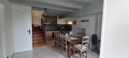 une salle à manger avec une table et des chaises et une cuisine dans l'établissement La Loge de Gabrielle - gîte - 3 étoiles, à Montlouis-sur-Loire
