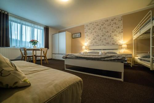 een hotelkamer met 2 bedden en een tafel bij Penzion Garden in Cerny Dul