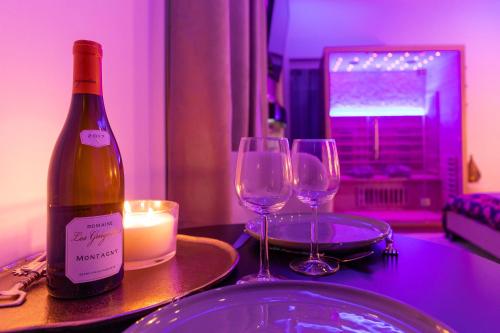 una bottiglia di vino seduta su un tavolo con due bicchieri da vino di Spa Edelweiss a Digione