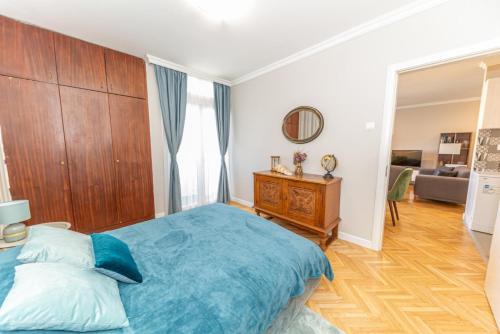 Schlafzimmer mit einem blauen Bett und einem Kopfteil aus Holz in der Unterkunft City center de Lux apartment in Bar