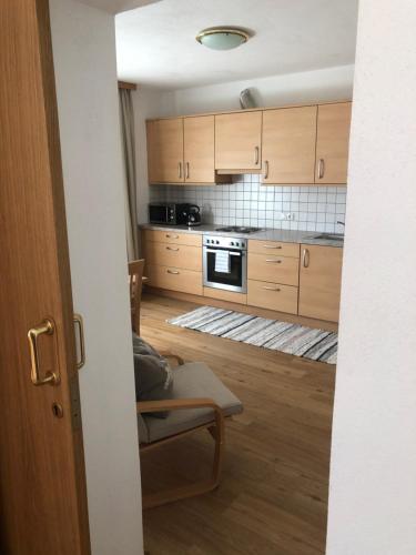 a kitchen with wooden cabinets and a stove top oven at Haus am Wald in Neustift im Stubaital