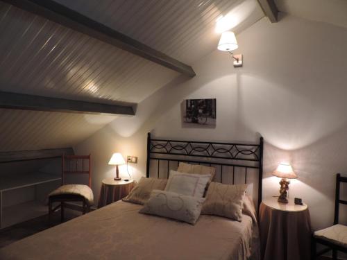 a bedroom with a bed with two lamps and two chairs at CASA GONDAR in O Grove