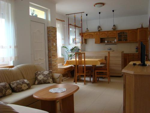 een woonkamer met een bank en een tafel bij Violetta Vendégház in Keszthely