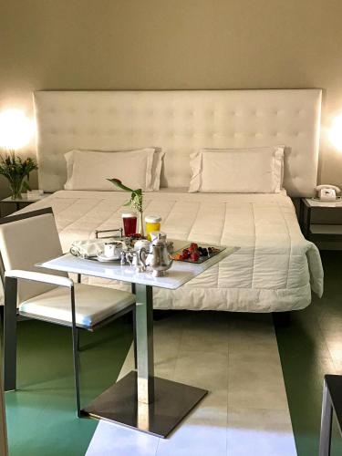 a large bed with a tray of food on it at Art Hotel Navigli in Milan