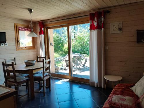 una sala da pranzo con tavolo, sedie e finestra di la ratavelaiza a Champagny-en-Vanoise