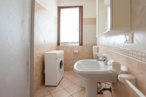 a bathroom with a sink and a washing machine at Smith 3B in Lido degli Estensi