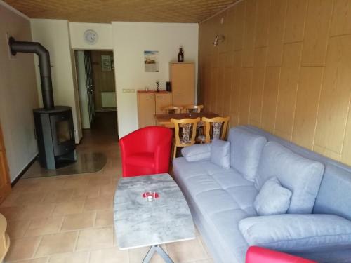 a living room with a couch and a red chair at Ferienwohnung Kleine Seite 16 in Görlitz