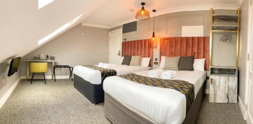 a hotel room with two beds and a desk at Comfotel GRN in London