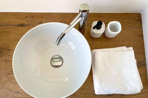 ein weißes Waschbecken auf einem Holztisch in der Unterkunft Design Apartment in the heart of Bolzano in Bozen