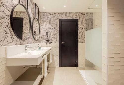 a bathroom with a sink and a mirror at Ilunion Alcora Sevilla in San Juan de Aznalfarache