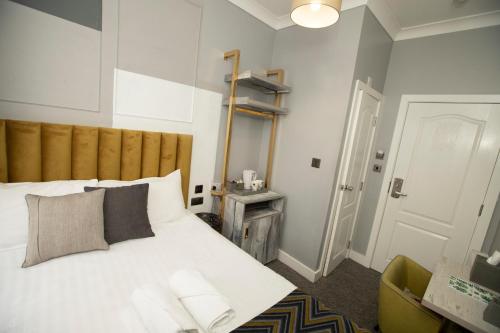 a bedroom with a white bed with a wooden headboard at Comfotel GRN in London