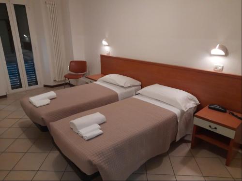 2 letti in camera d'albergo con asciugamani di Albergo Italia ad Ancona