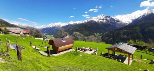a farm with cows on a green field with mountains at Chalet Cormignano in Vezza dʼOglio