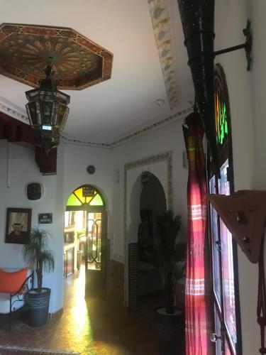 a hallway of a building with a door and a window at Les Jardins de Ryad Bahia in Meknès