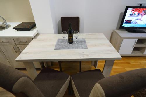 ソコバニャにあるApartman Alegroのワイン1本とグラス2杯付きのテーブル