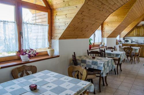 un comedor con mesas, sillas y ventanas en Bodó Ház en Gyenesdiás