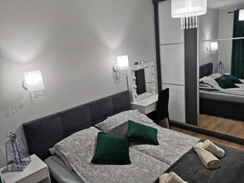 ギジツコにあるLucky Marinaのベッドルーム1室(緑の枕と鏡付きのベッド1台付)