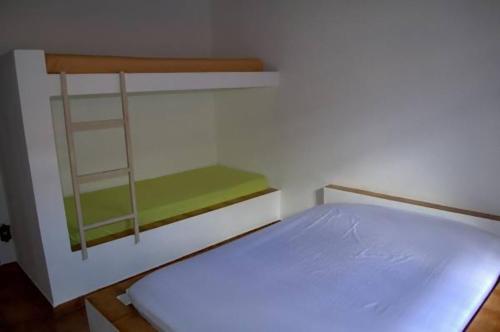a small bedroom with a bunk bed with blue sheets at Chalé Massaguaçu in Caraguatatuba