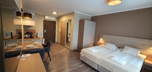 Habitación de hotel con cama grande y escritorio. en Apartamenty Bel Mare Międzyzdroje ATK Zarządzanie, en Międzyzdroje