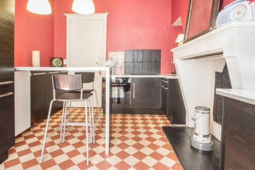- une cuisine avec des murs rouges et un sol en damier dans l'établissement au cœur du quartier historique, à Bordeaux