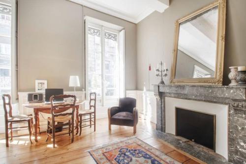 - un salon avec une cheminée, une table et des chaises dans l'établissement au cœur du quartier historique, à Bordeaux