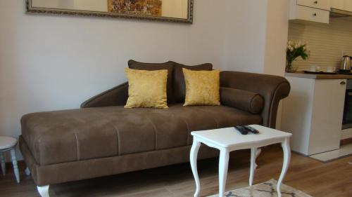 un sofá marrón en una sala de estar con una mesa blanca en Gagovic en Cetinje