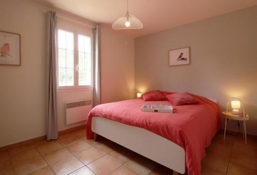- une chambre avec un lit doté d'une couverture rouge et d'une fenêtre dans l'établissement Domaine du Flamand - Gîtes du Pin Sec côté OCEAN, à Naujac-sur-Mer