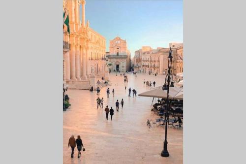 a group of people walking down a city street at SEA-VIEW TERRACE & BIKES Moon Ortigia Holiday Home in Siracusa