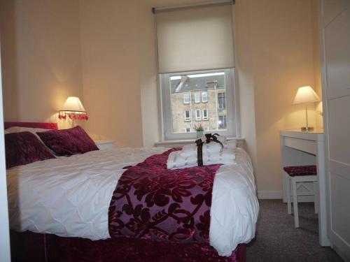 a bedroom with a large bed and a window at Fabulous location, One Bedroom West End Flat, just off Byres rd, close to SEC & Hydro in Glasgow