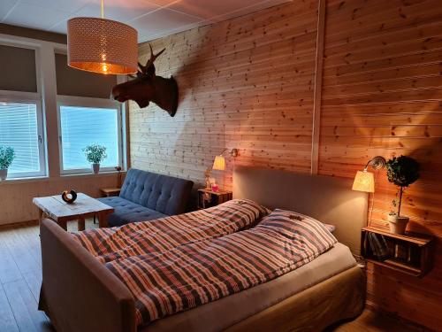 ein Schlafzimmer mit einem Bett und einem blauen Sofa in der Unterkunft Gästhus Nornäs in Nornäs