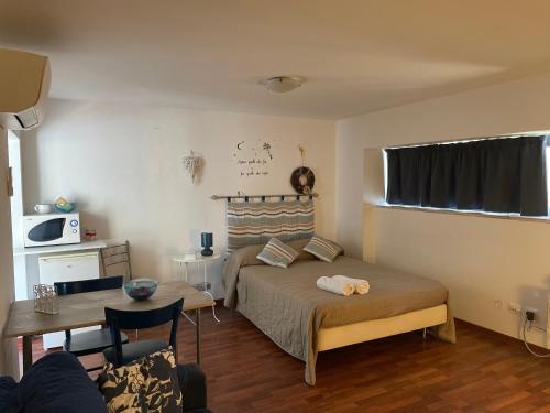 a bedroom with a bed and a table and a microwave at Blue Apartment in Pescara