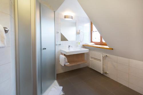 y baño con lavabo y ducha. en Landgasthof Vogelsang OHG en Weichering