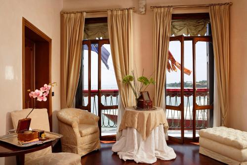 a living room with large windows and a table and a chair at Porta da mar in Venice