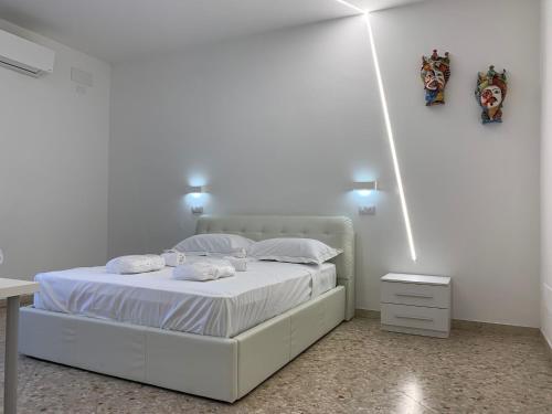 a bedroom with a white bed with two pillows at Catania Apartment Borgo Suite Autonomous in Catania
