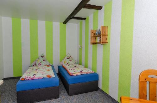 シャプローデにある2-Personen-Appartement-in-Schaprodeの緑と白のストライプを用いた客室内のベッド2台