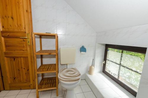 ein Bad mit einem WC und einem Fenster in der Unterkunft 3-Raum FeWo für 5 Personen + 1 Aufbettung auf Rügen in Schaprode