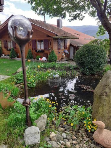 a garden with a pond and a statue in front of a house at Ferienwohnung Arberblick in Lam