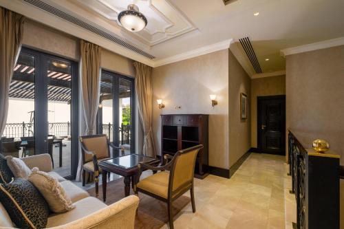 a living room with a couch and a table at Zabeel Saray Royal Residences Lagoon Villa in Dubai