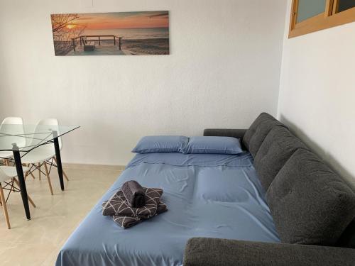 Sunny Beach Retreat في سانتا بولا: سرير في غرفة مع أريكة وطاولة