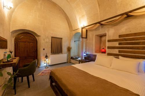 a bedroom with a bed and a desk in a room at Lemon Cave Suites in Avanos