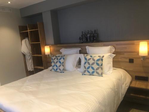 a bedroom with a white bed with blue and white pillows at Luxury Zen in Châteauneuf