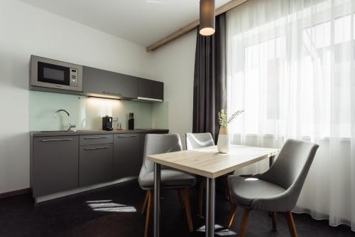 a kitchen with a table and chairs and a microwave at Hotel Smart Liv'in in Böheimkirchen