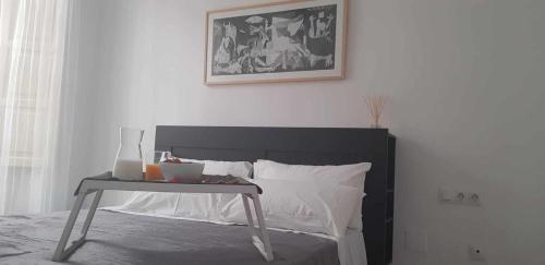 a bedroom with a bed with a table next to it at Acogedor Apartamento en el Corazón de Málaga in Málaga