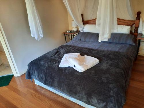 Orana"Welcome" Cabin in The Tops في Bandon Grove: سرير عليه منشفة في غرفة النوم